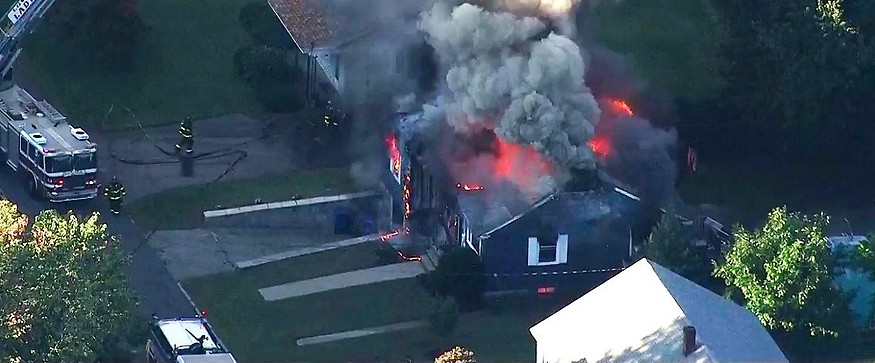 Luftaufnahme eines Hauses, aus dem Flammen und Rauch steigen