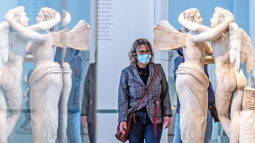 Eine Frau mit Schutzmaske geht durch ein Museum