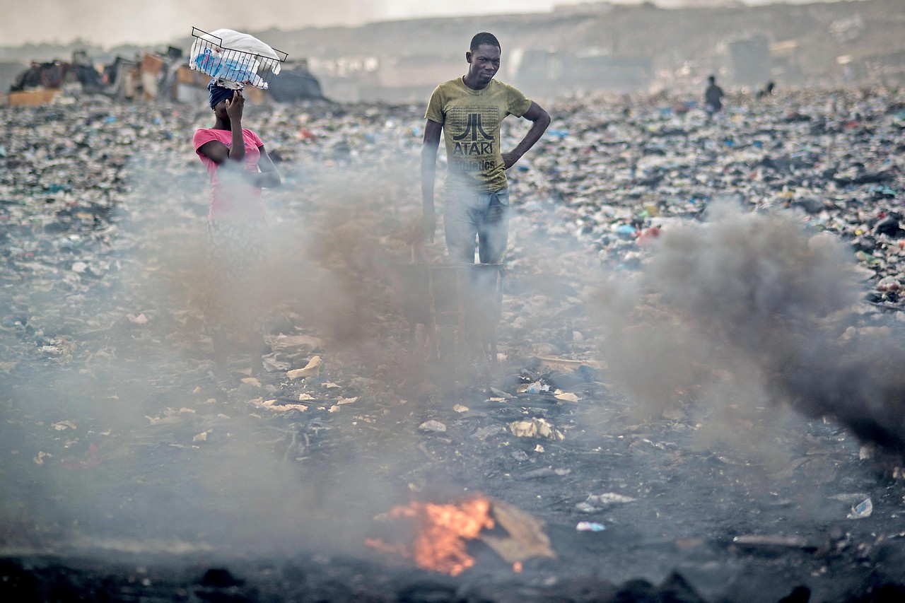 A man burns electronic waste at the Agbogbloshie landfill in Accra, Ghana