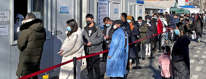 Menschen stellen sich in Peking vor einer CoV-Teststation an