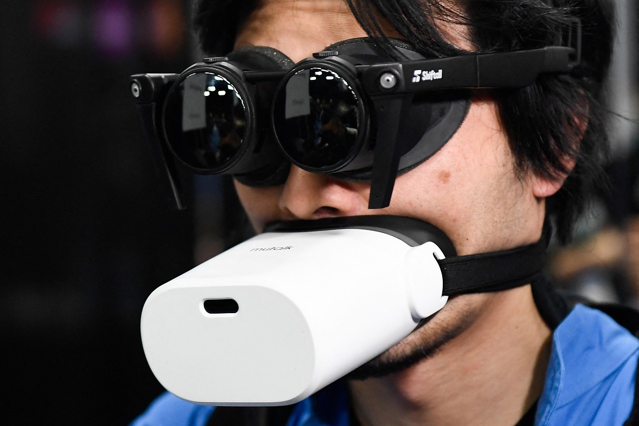 Mann trägt VR-Headset am Kopf und VR-Mikrofon über Mund