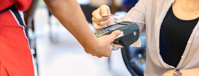 Frau zahlt in einem Restaurant mit ihrer Kreditkarte