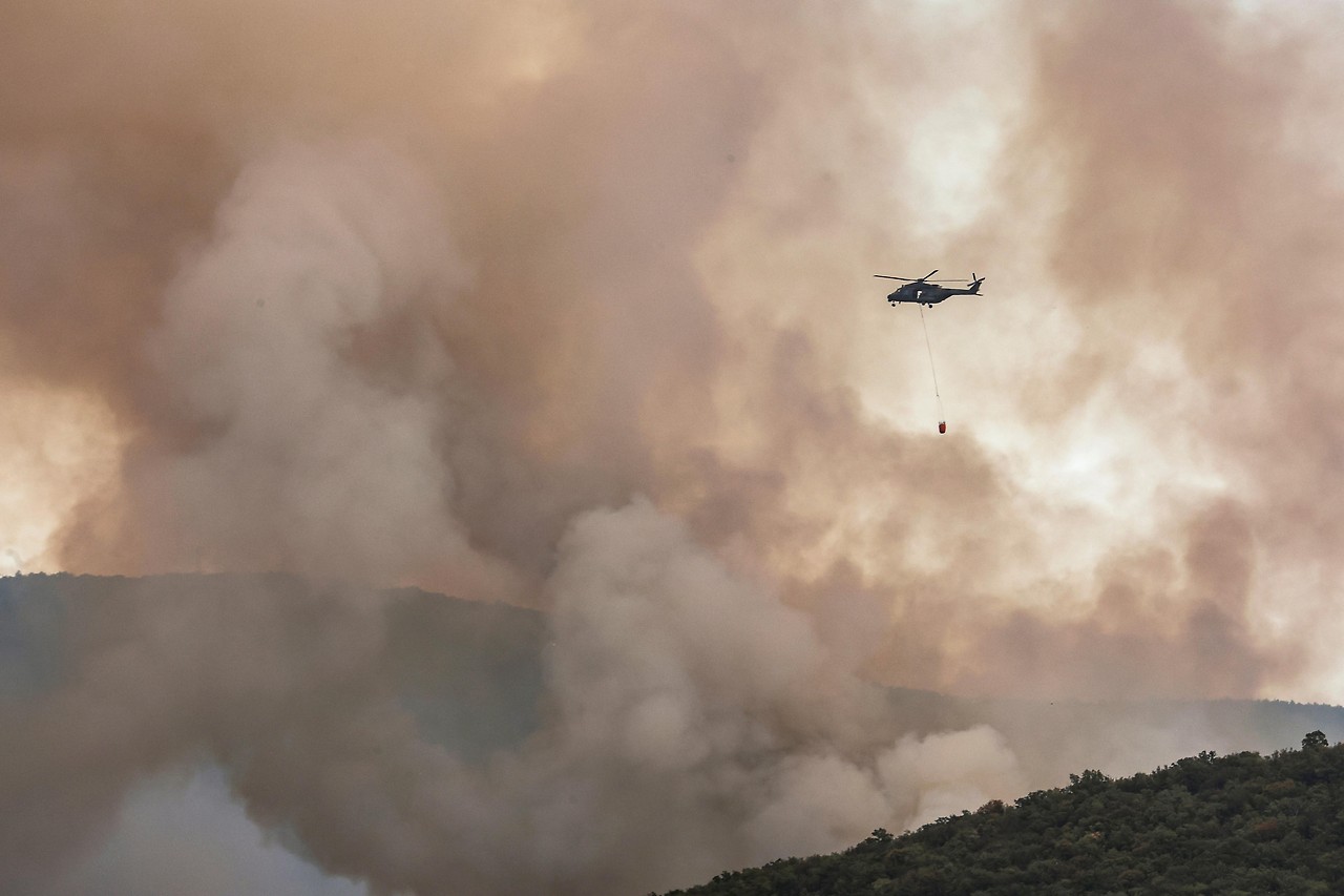 Un elicottero antincendio sorvola Zamiano (Italia).