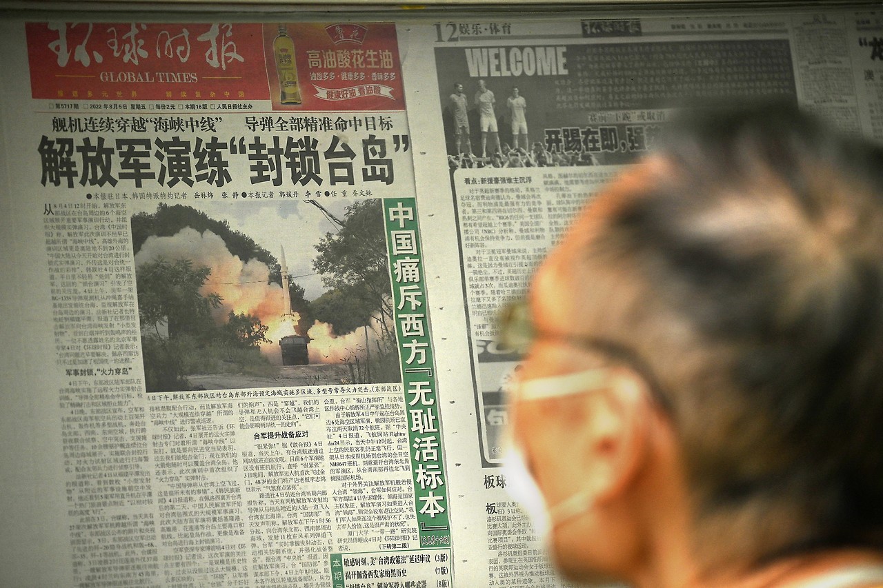 Un hombre mira un reportaje periodístico sobre las maniobras chinas en Pekín