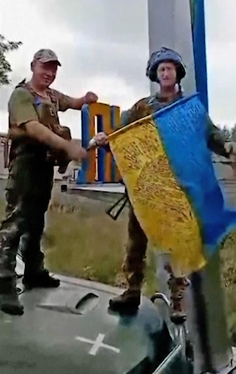 Soldaten mit ukrainischer Flagge in Lyman