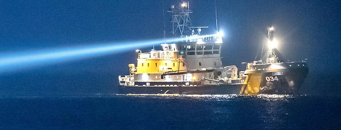 Ein Schiff der schwedischen Küstenwache hat einen Scheinwerfer auf das Meer gerichtet