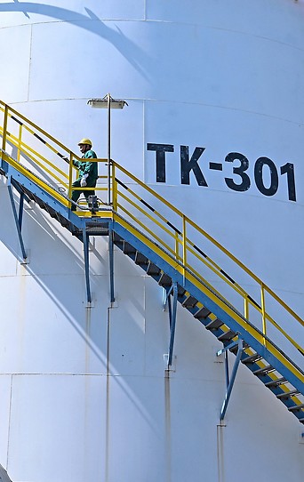 Ein Arbeiter auf den Außenstiegen eines Öltanks
