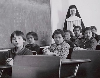 Archivfoto von Schülern in einer Klasse der Cross Lake Indian Residential School in Kanada mit einer Nonne im Hintergrund