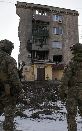 krainische Soldaten vor schwer beschädigtem Gebäude in Bachmut