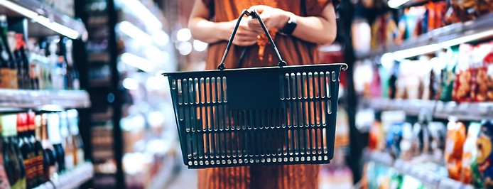 Eine Frau mit Einkaufskorb im Supermarkt