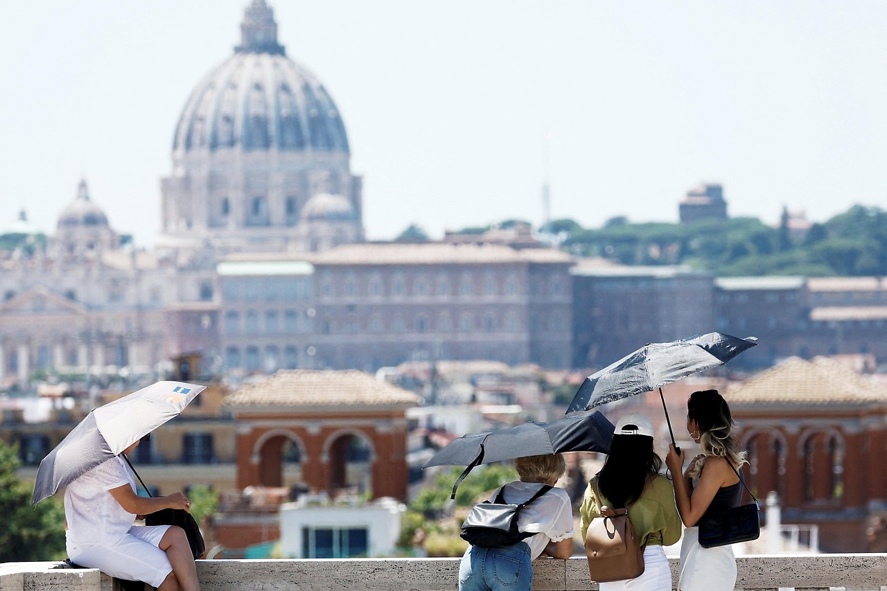 Tourists in Rome standing under umbrellas