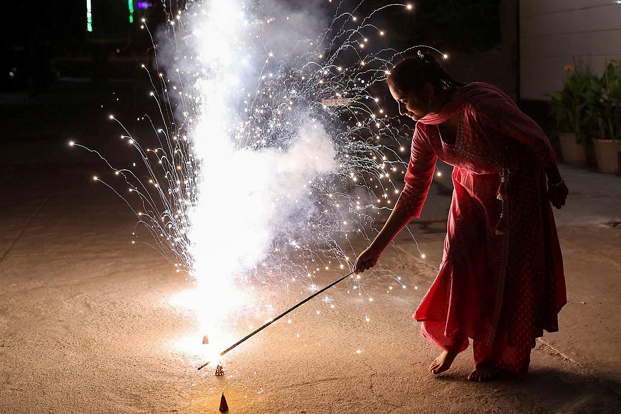 Seorang gadis menyalakan kembang api di New Delhi