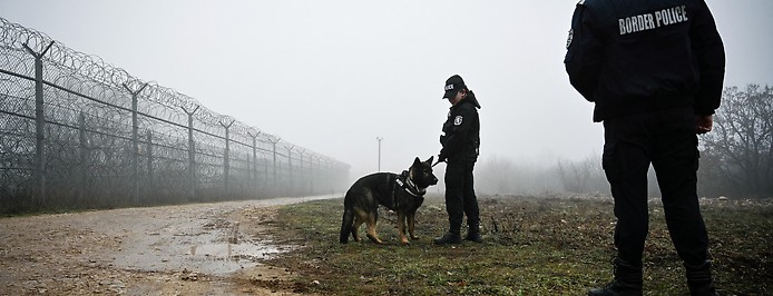 Grenzpolizei mit Hund bewacht den Grenzzaun an der Bulgarischen Grenze