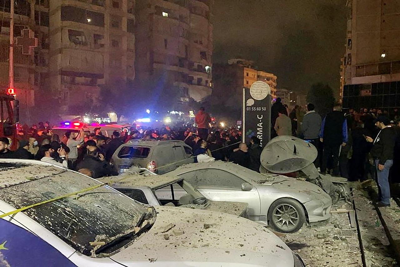 People and vehicles in front of a damaged building in Beirut