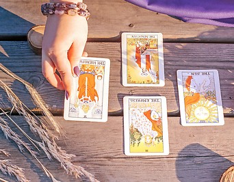 eine weibliche Hand legt Tarotkarten auf