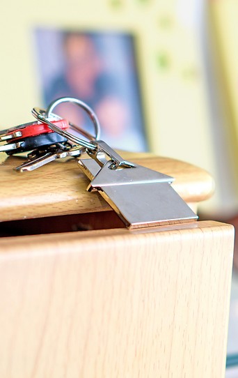 Schlüsselbund mit Haussymbolanhänger auf einem Kästchen