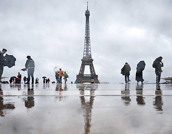 Besucher blicken im Regen auf den Eiffelturm in Paris