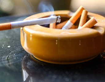 Brennende Zigarette auf einem Aschenbecher