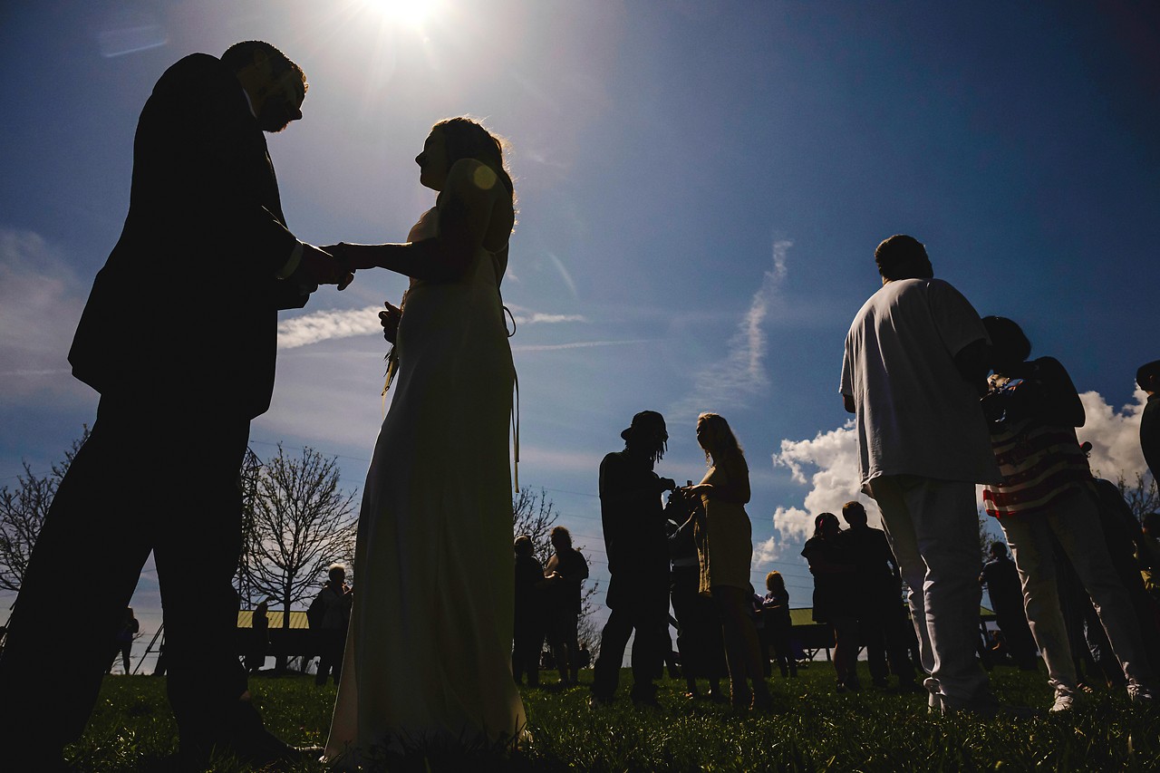Couples exchange rings in a mass wedding ceremony during a solar eclipse