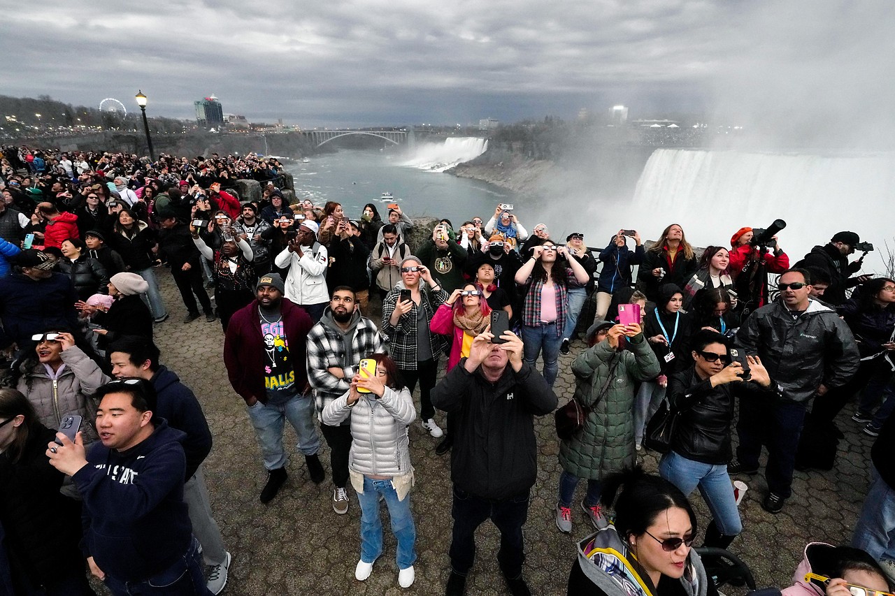 People gather in front of Niagara Falls for the solar eclipse