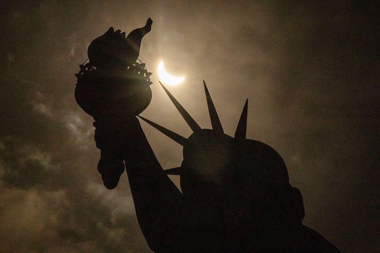 Solar eclipse with Statue of Liberty in foreground