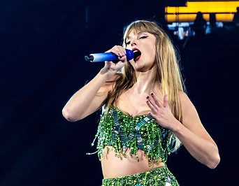 Sängerin Taylor Swift in grünem Paillettenkleid bei einem Konzert