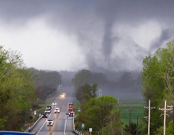 Autos auf Straße, Tornado im Hintergrund