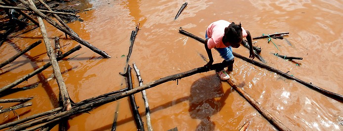 Mädchen in Trümmerteilen an einer überschwemmten Straße